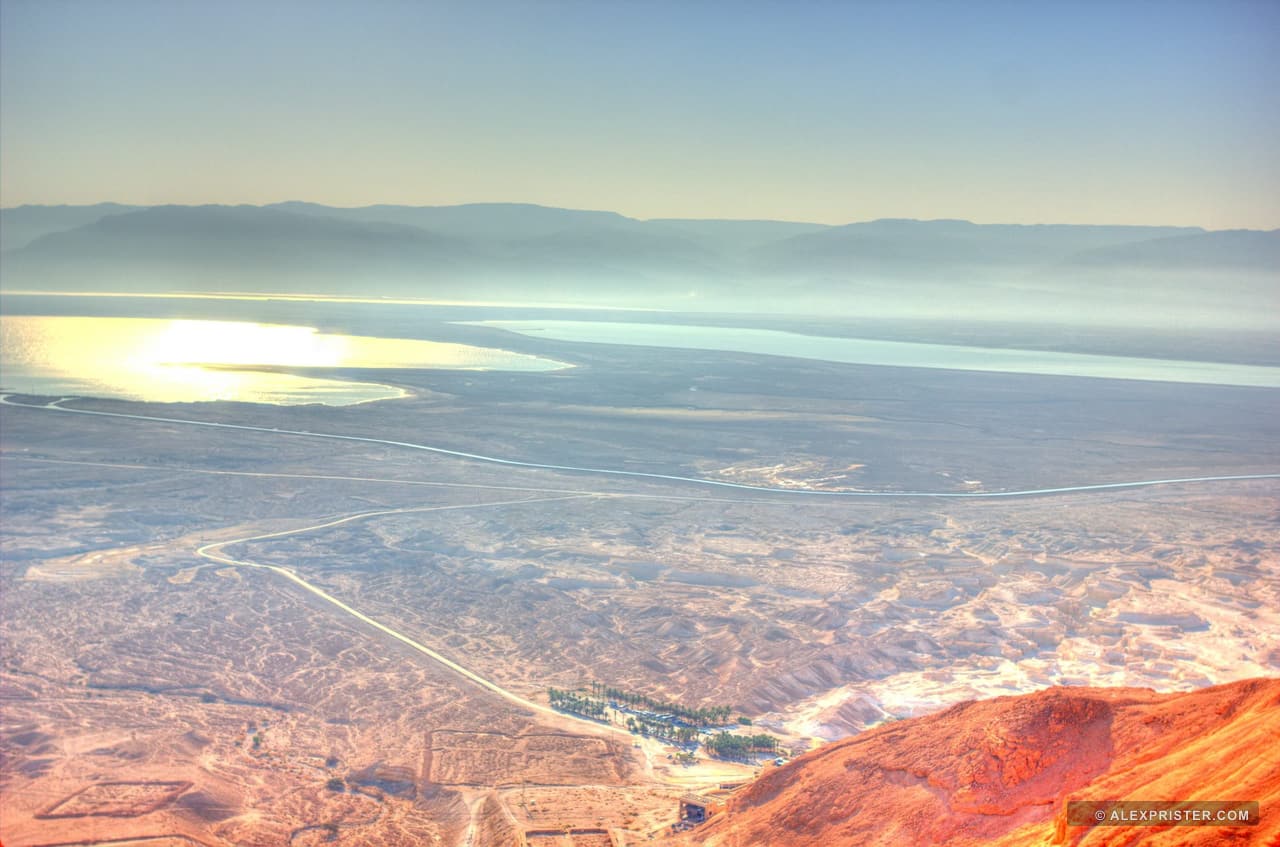 A high-altitude view divided by clouds, reflected light, and desert terrain