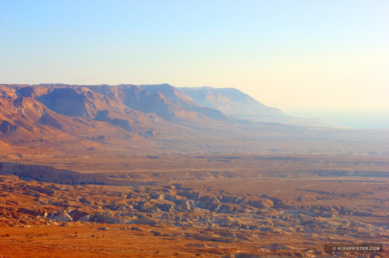 A long desert escarpment above roads and settlements in a wide valley