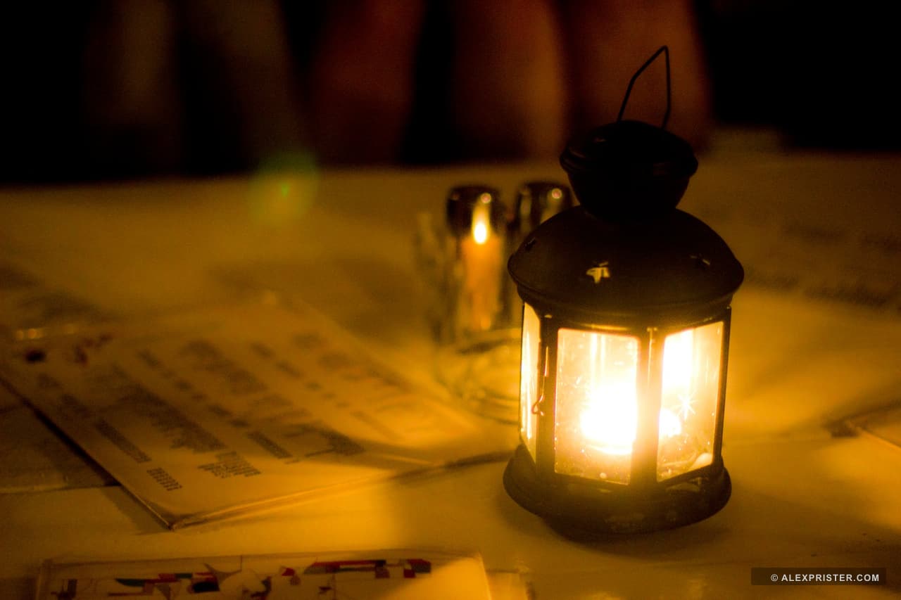 A small glowing lantern casting warm light across papers on a table